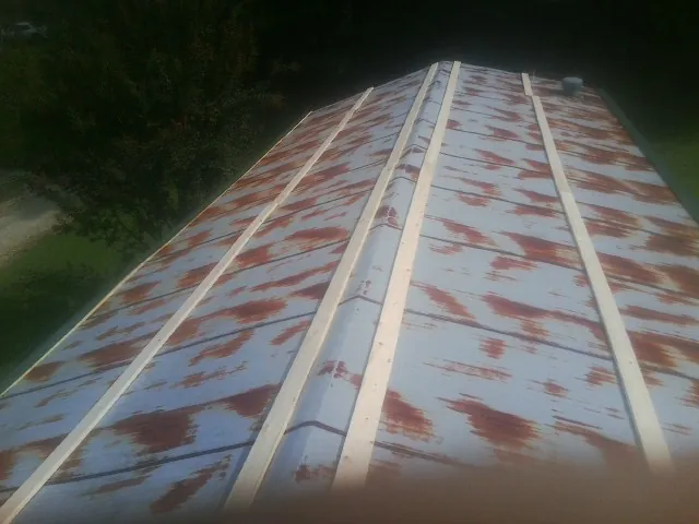 Rusted metal roof panels with new wood purlins before replacement — Storm Damage Roof Repair in Cheney by Roofing Brothers